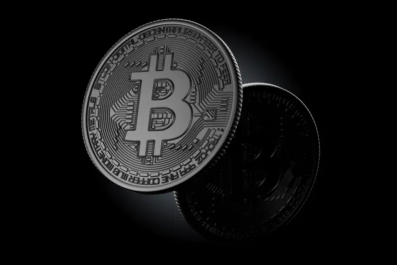 A physical bitcoin token against a dark background.