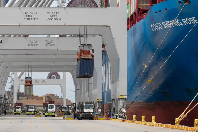 Cranes loading containers at a shipping port.